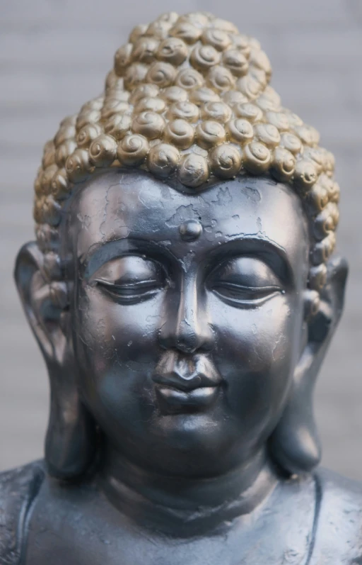 there is a statue of a buddha with lots of small circles on his head