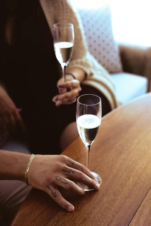 a woman holding a glass of wine while sitting down