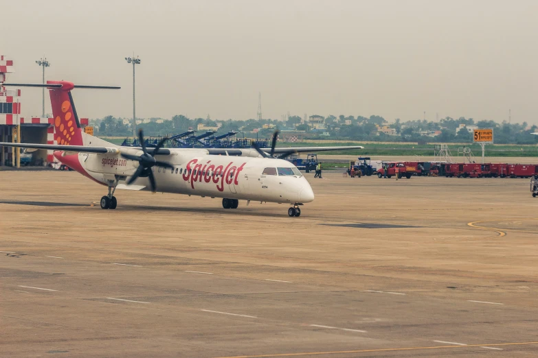 a small plane sits on the runway in front of a crowd of people