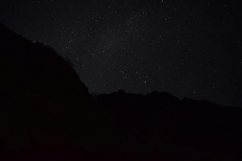 the mountains and stars are silhouetted against the dark sky