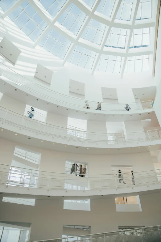 a group of people sitting on chairs in the middle of a white building