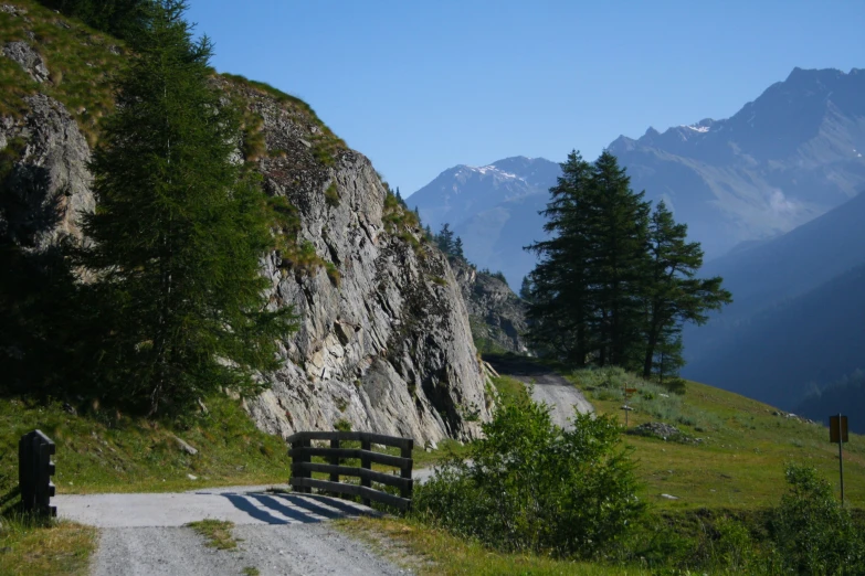 a wooden bench sitting on the side of a hill