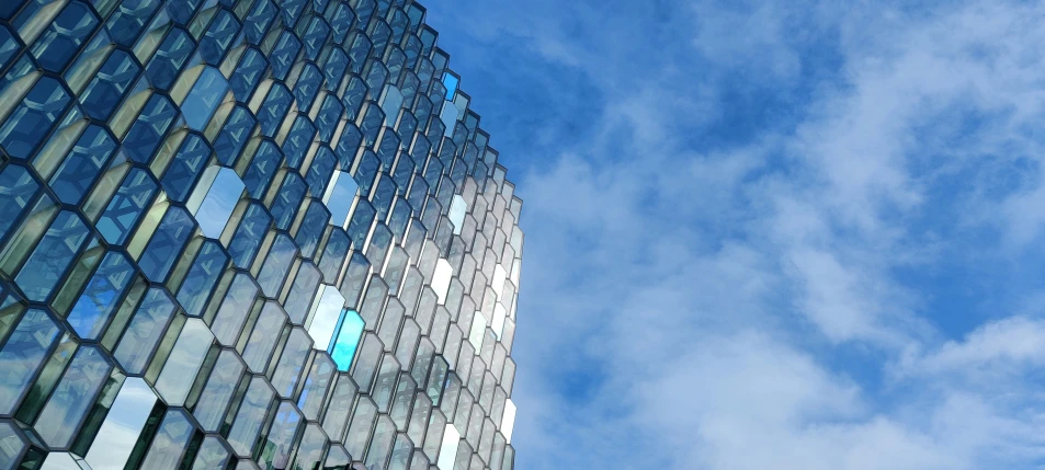 the facade of a high - rise glass building against blue sky