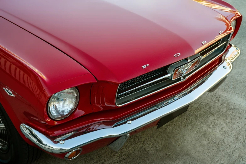 the front end of an old style red mustang