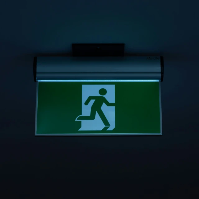 a green emergency sign that has a silhouette man