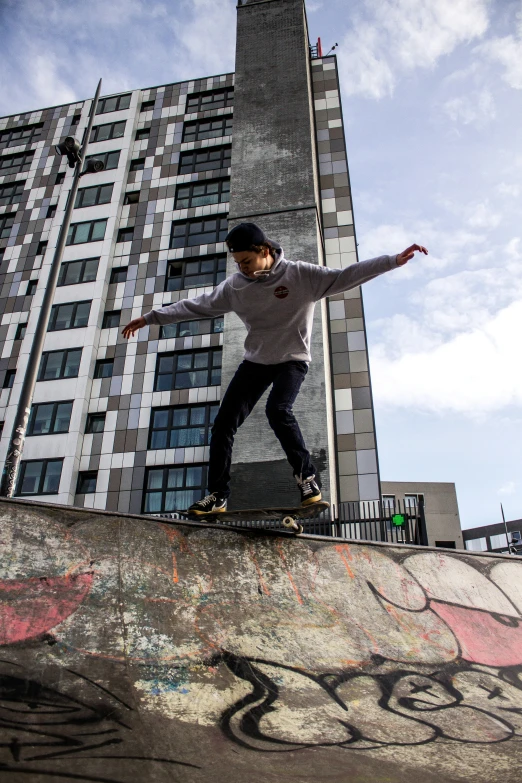 a young man riding a skateboard up the side of a cement wall