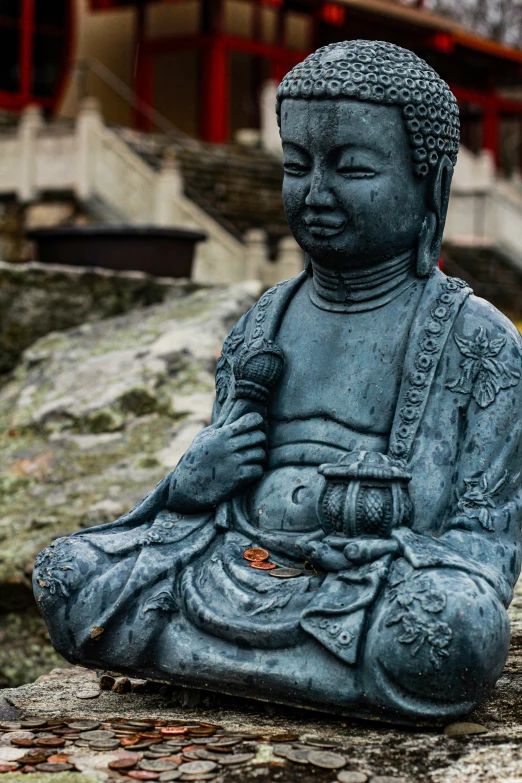 the statue of buddha sitting outside of a building