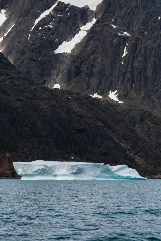 a large iceberg sitting on top of a mountain near the ocean