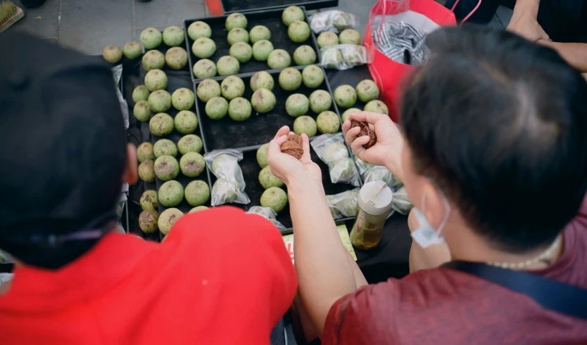 people in the street near many apples for sale