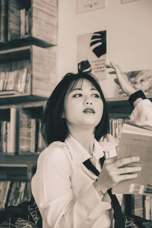 a woman wearing a tie sitting down and reading a book