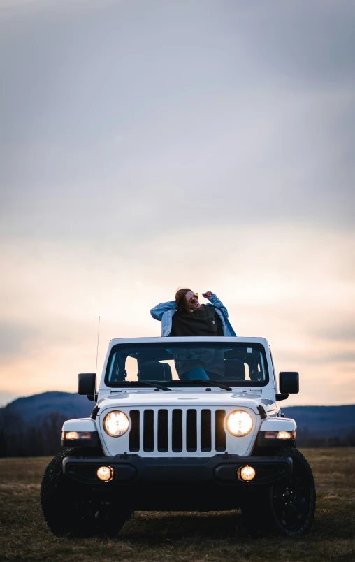 a white jeep with the top off on the grass