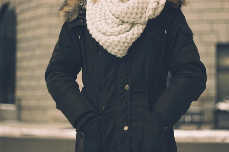 a person in black jacket with white scarf