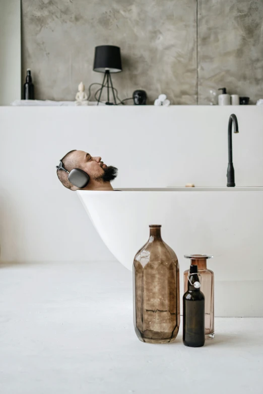 a bathroom sink and vase filled with small items