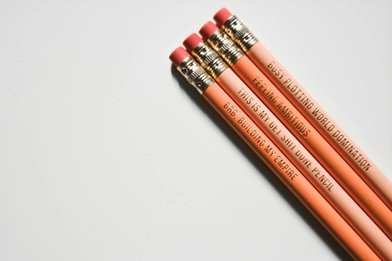 three pencils side by side on a white surface