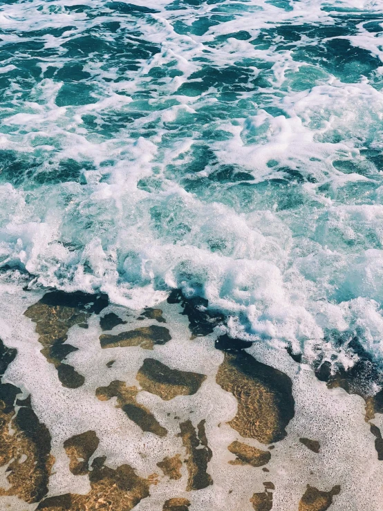 ocean waves on the sandy beach with green sky