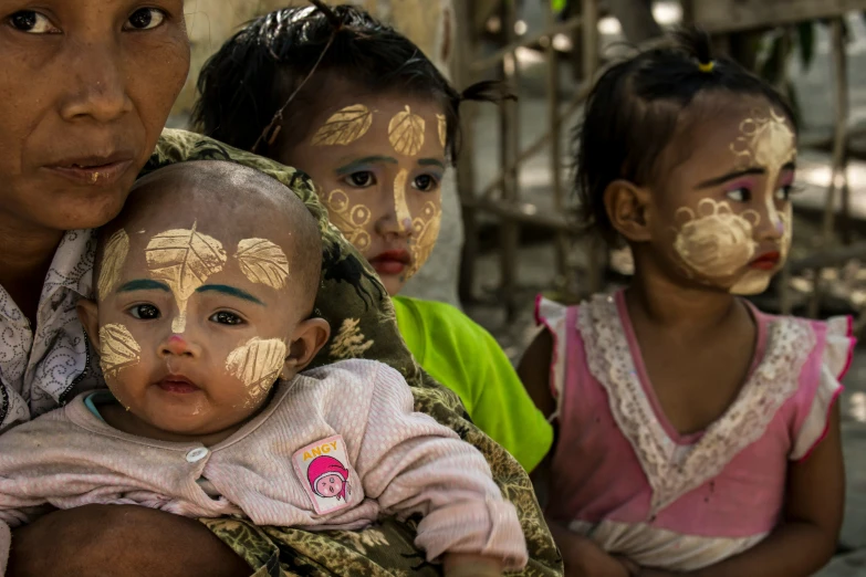 a group of s with faces painted in gold