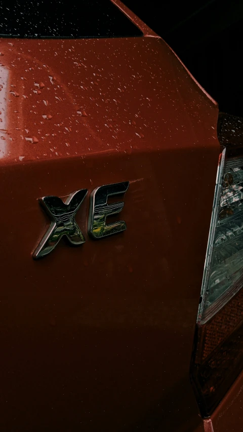 a close up of a mustang badge on a red car