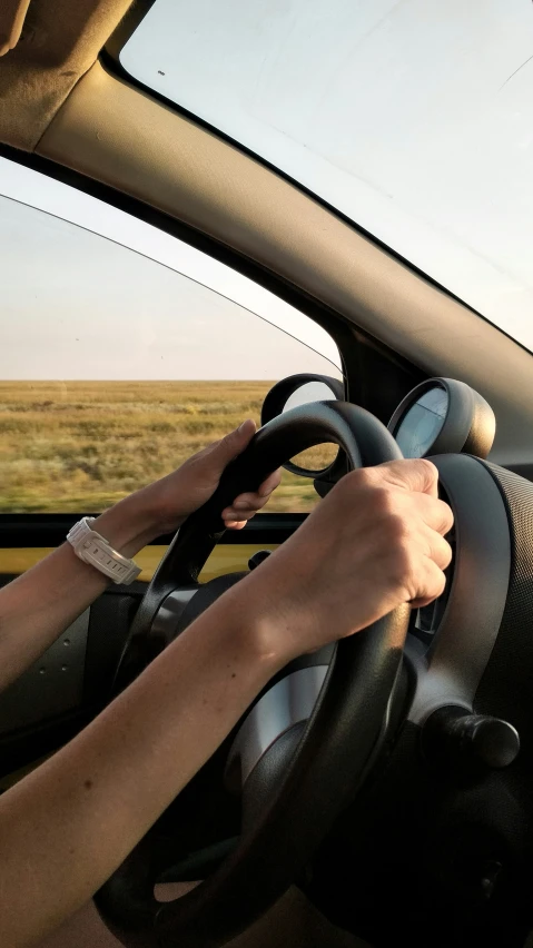 person driving a car on a open plain road