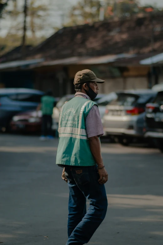 man on skateboard standing in parking lot with houses