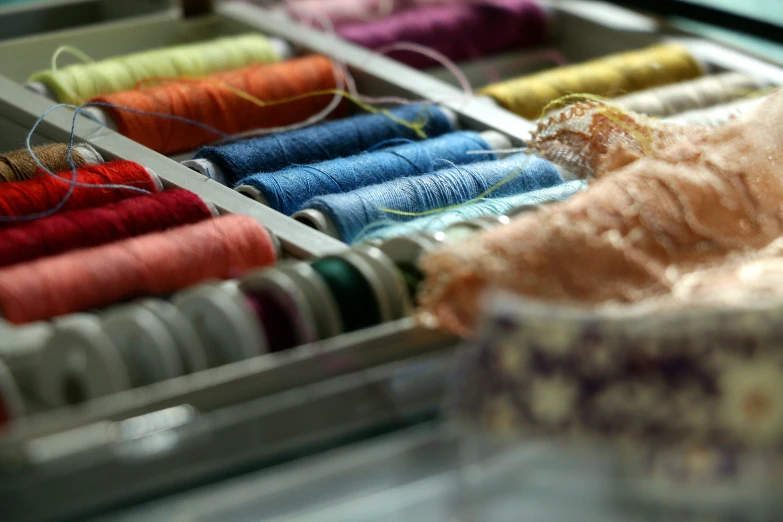 several thread spools sit in a display case