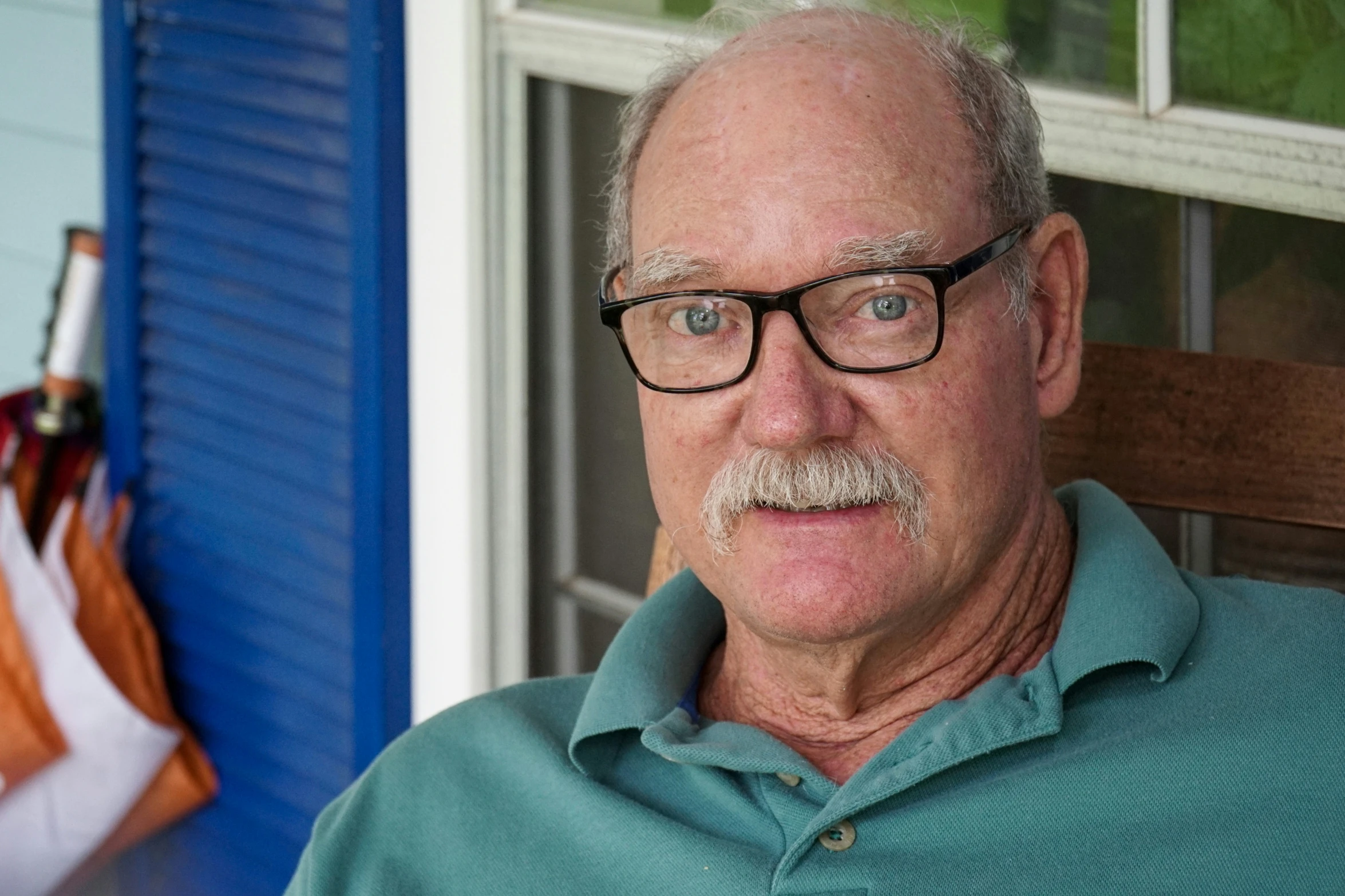 an old man with glasses wearing a green shirt