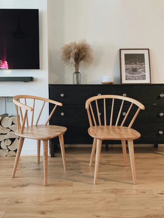 two chairs sitting next to each other in front of a wall