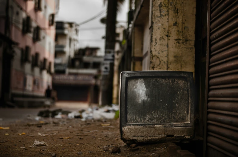 an old tv set sitting in the street next to a building