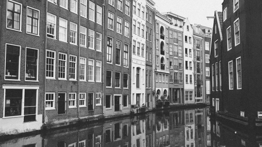 old buildings near water line with reflection in water