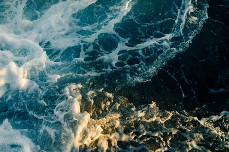 a wave rolls into the beach next to the shore