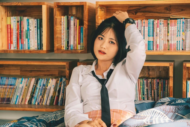 a woman sits on the bed in front of bookshelves