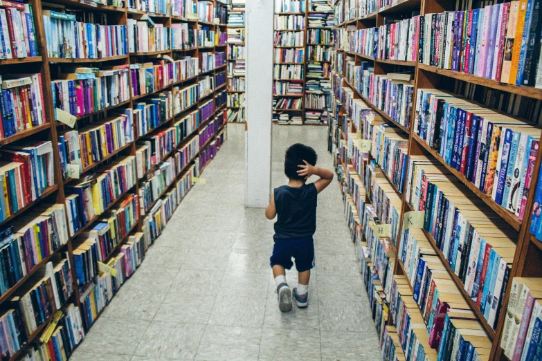 a child stands alone in a liry of books