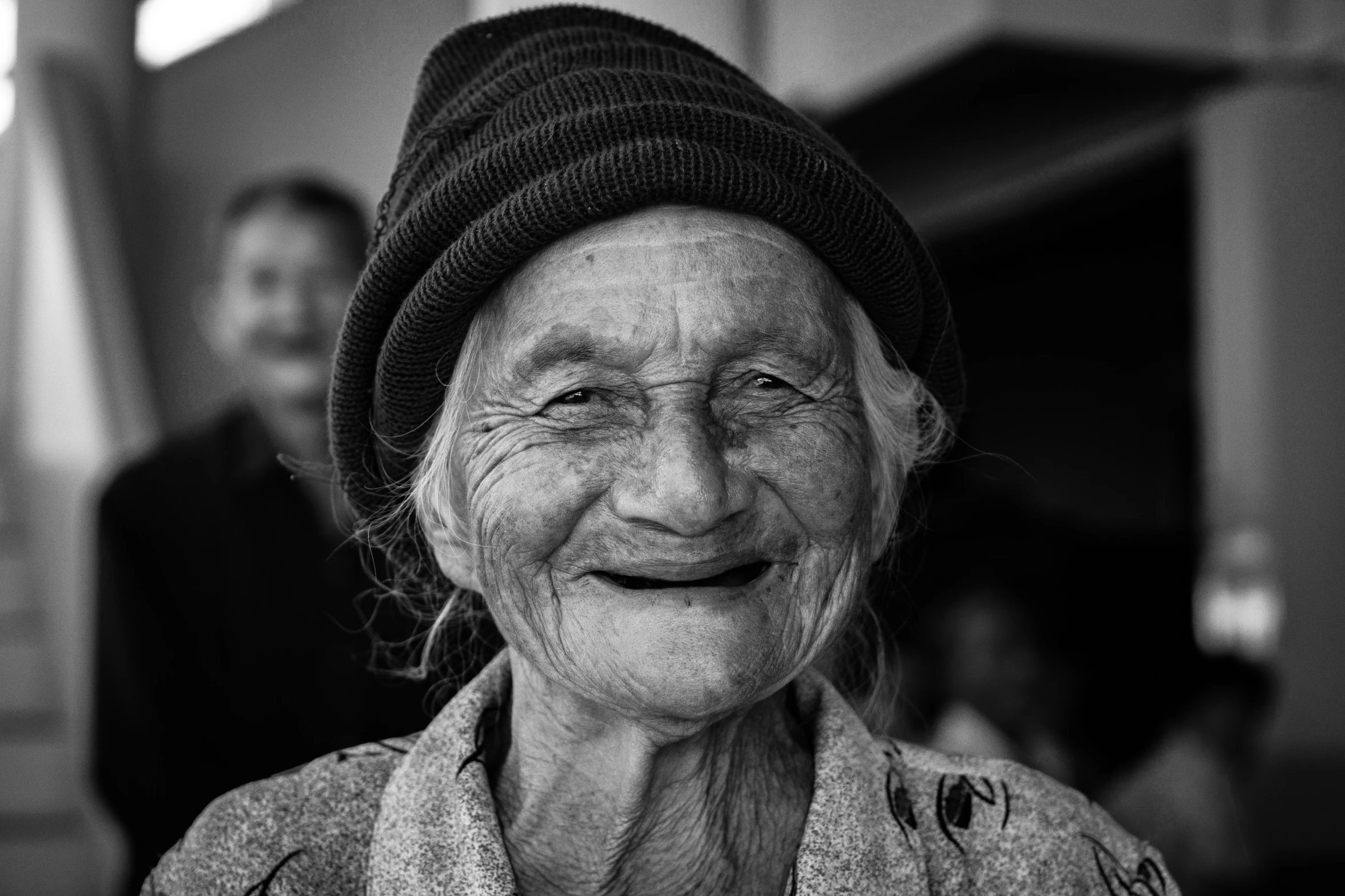 a smiling woman in a black hat is shown