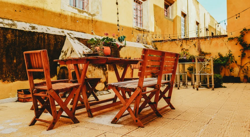 there are some chairs and table set outside in the sun