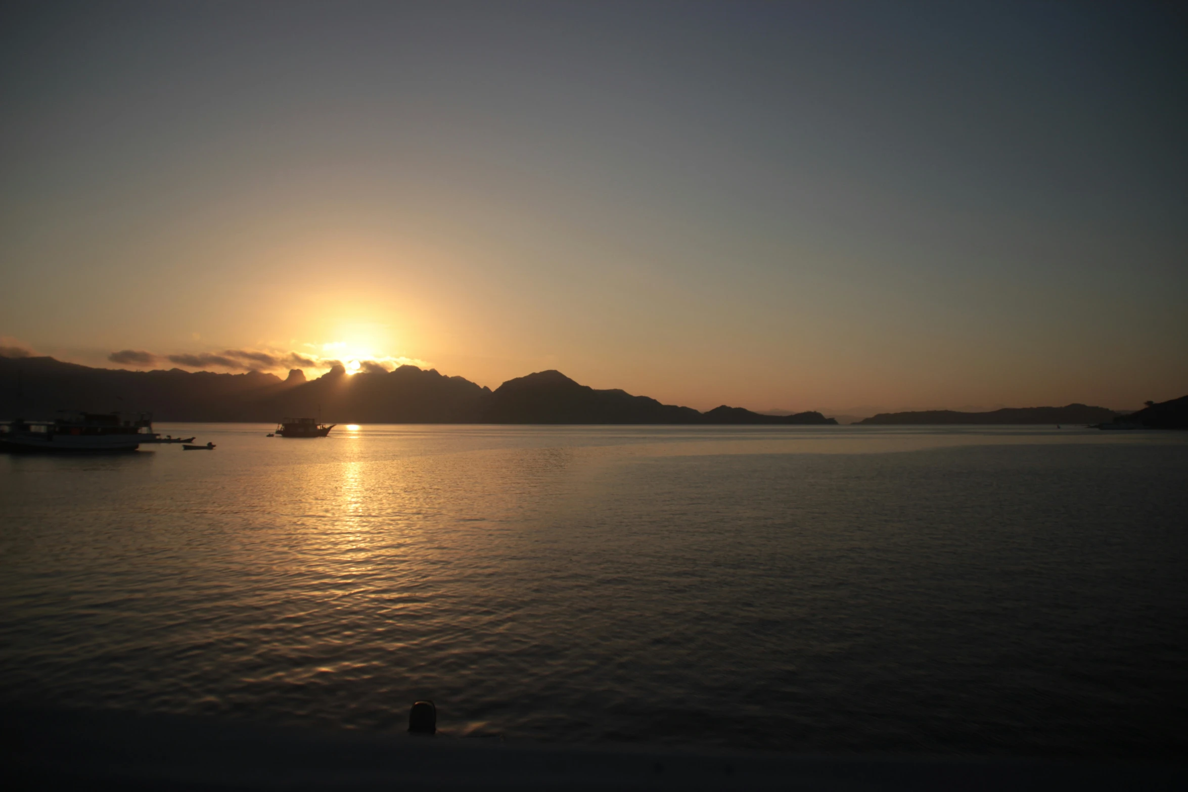 the sun is setting over a large lake