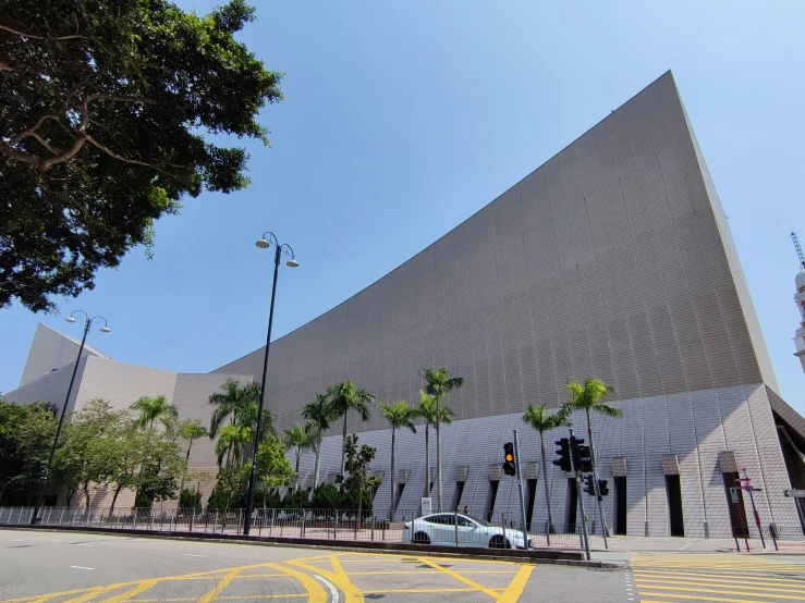 a large triangular shaped building with palm trees next to it