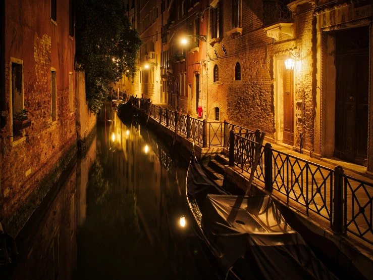 an old boat in a canal is parked at night