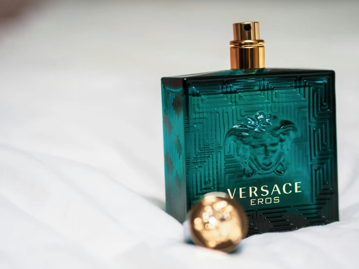 a bottle of perfume sitting on top of a bed