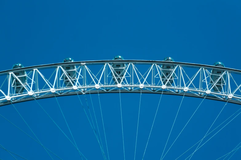 the front side of a ferris wheel against a blue sky