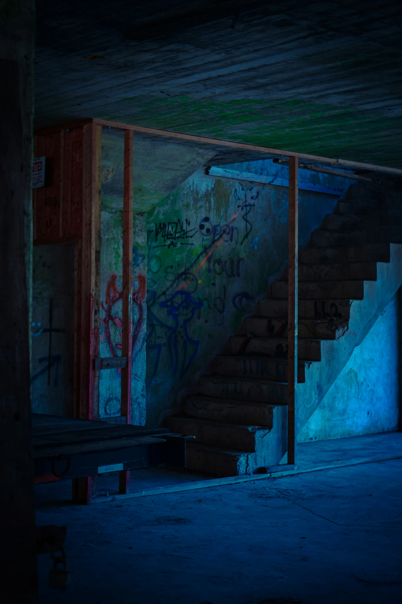 an abandoned stairway with graffiti, steps and storage area