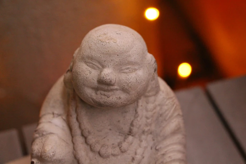 there is a statue of a baby buddha holding his arms and legs