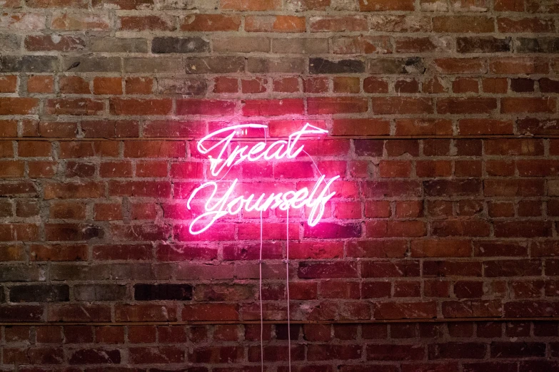 a bright neon sign in front of a brick wall