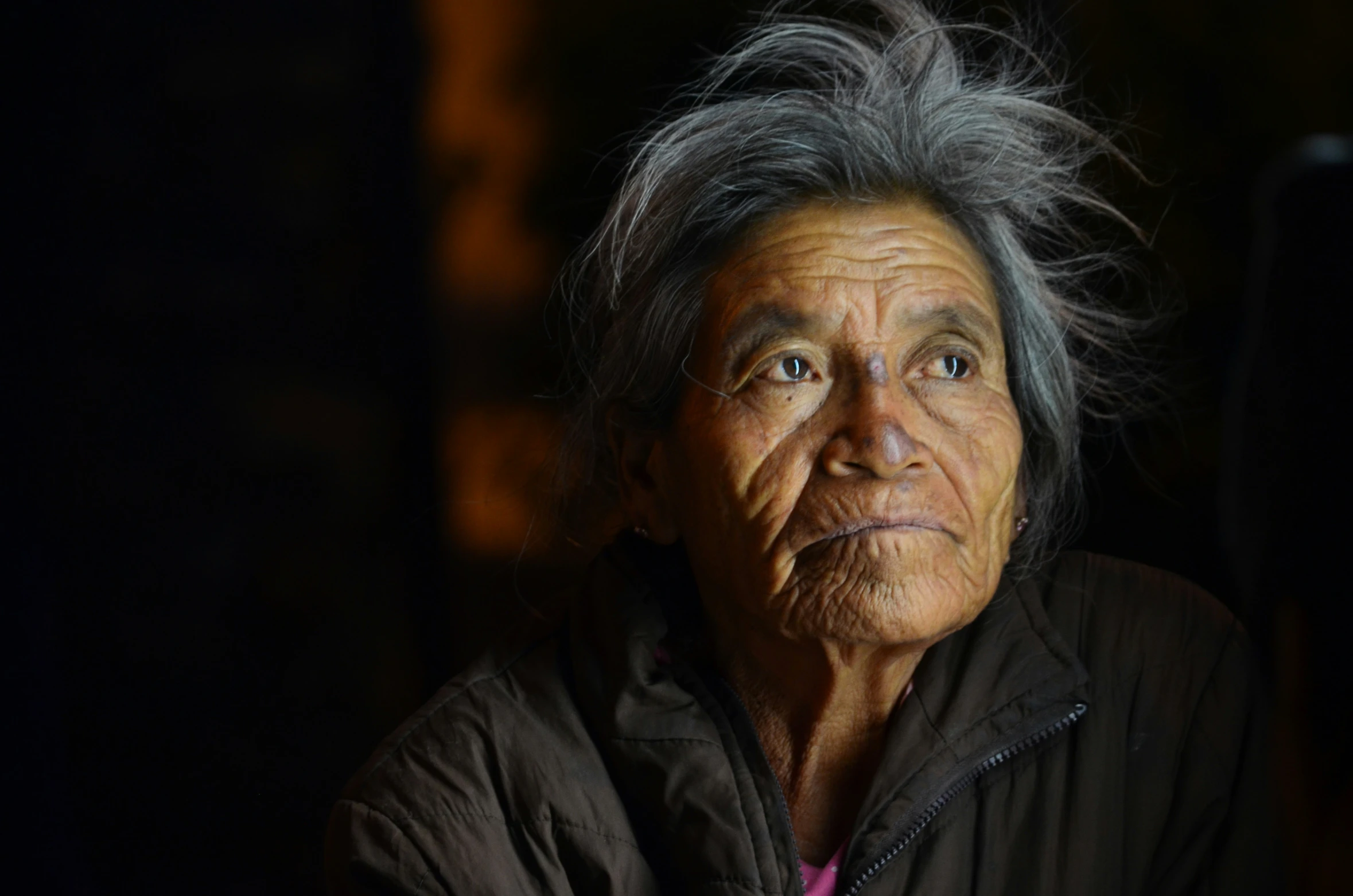 an old woman with gray hair looking up