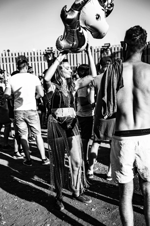 group of people standing around holding up pairs of shoes