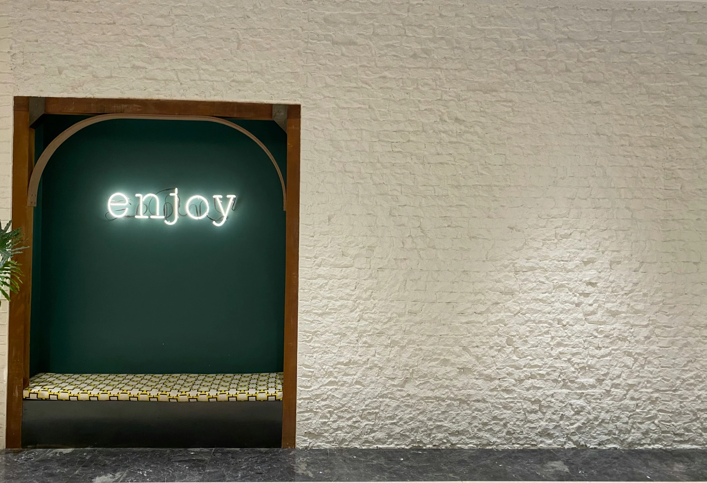 a sign that says enjoy and is lit up in a doorway