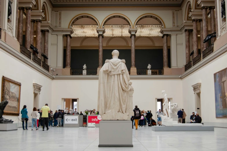 a statue is sitting in a room with many people