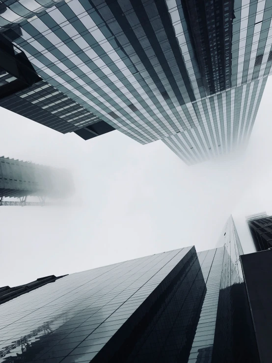 skyscrs standing in the fog, looking up from the ground