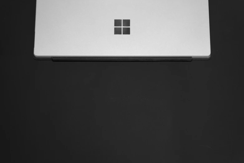 the microsoft logo is displayed on top of a laptop computer