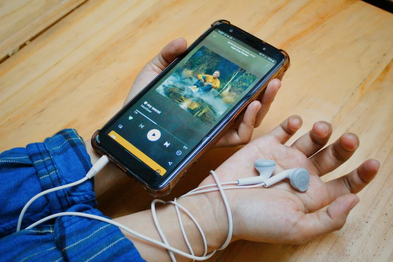 a person holding their cell phone up to the charger