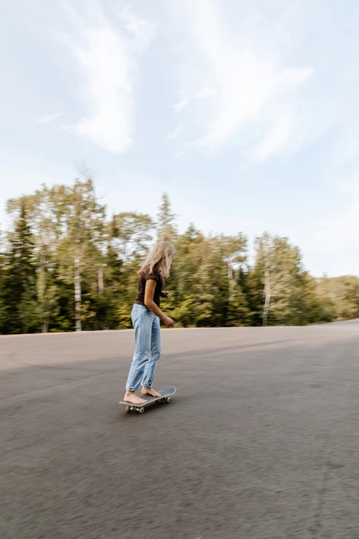 a girl riding on a skateboard down the road