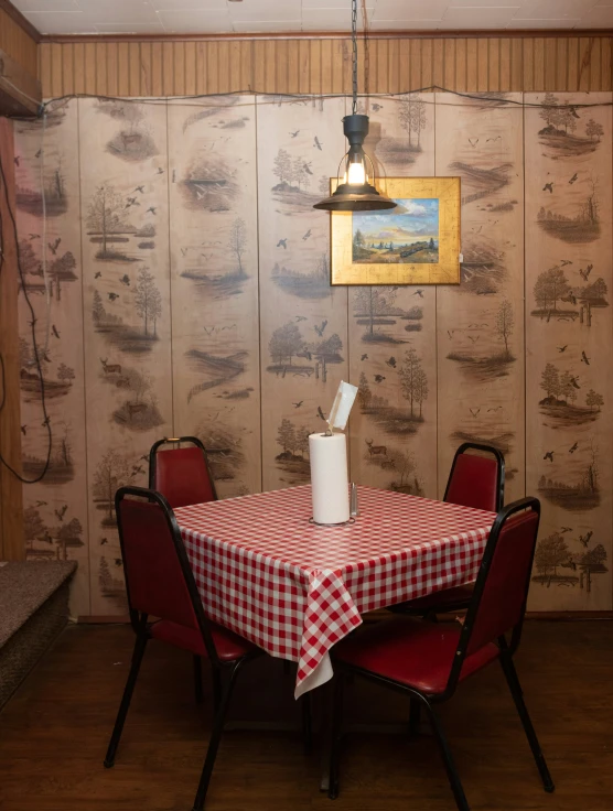 red chair sitting at a table with a checkered tablecloth on it